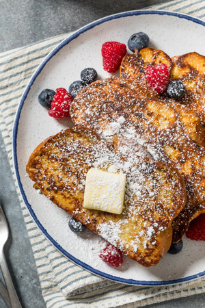Sweet Homemade Challah French Toast with Powdered Sugar and Berriesの写真素材