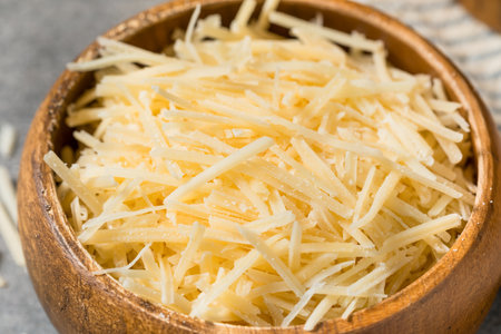 Organic Raw Shredded Parmesan Cheese in a Wood Bowlの写真素材
