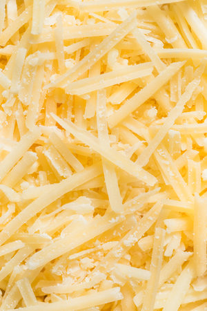 Organic Raw Shredded Parmesan Cheese in a Wood Bowlの写真素材