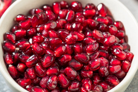 Organic Raw Red Pomegranate Seeds in a Bowlの写真素材