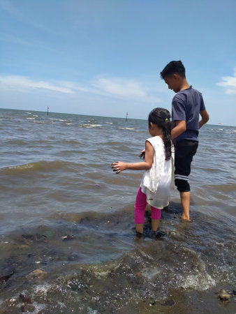 Asian boy and girl playing on the beach in the sea, Thailand.の写真素材