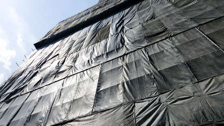 under construction building that covered by black canvasの写真素材
