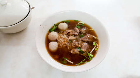 Chinese oriental meat noodle food on white bowl and white table, it's a delicious food from Asiaの写真素材