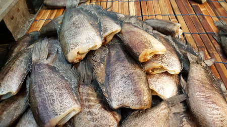 salted or dry fishes are placed in the bamboo table to selling for customer in the marketplaceの写真素材