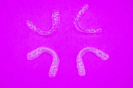 clear plastic retainer teeth that isolated on purple  background. it's an equipment for orthodontist...