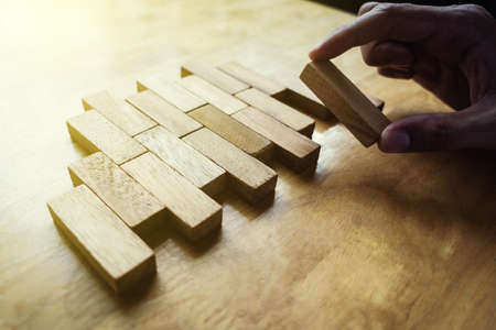 The way planning for business growth with wooden blocks, hand of  man is putting wooden block finally piece, plan and strategy in business.   の写真素材