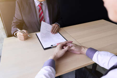 Interview employee reading a resume with the job seeker sitting in front, Job applications concepts.の写真素材