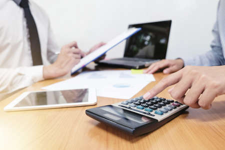 Businessman is calculating the budget and taking about work with his team.の写真素材