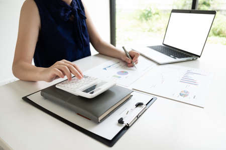 Business women is calculating revenue from graph in the room and work from home, Finance and accounting concept.の写真素材