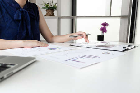 Business women is calculating revenue from graph in the room and work from home, Finance and accounting concept.の写真素材