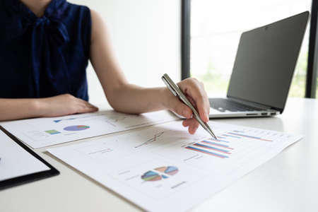 Business women is analyzing marketing strategy from the selling performance graph in the room and work from home, Finance and accounting concept.の写真素材