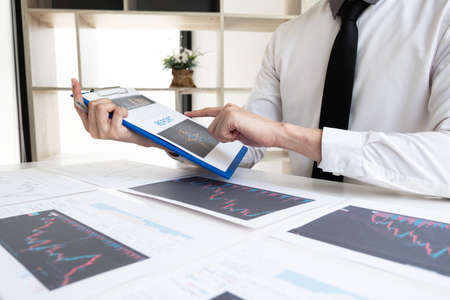 Businessman is analyzing stock graph for planning strategy of investment in the office room, Business and finance concept.の写真素材