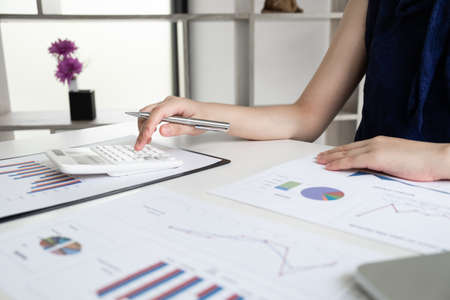Business women is calculating revenue from graph in the room and work from home, Finance and accounting concept.の写真素材