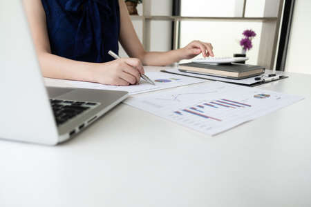 Business women is calculating revenue from graph in the room and work from home, Finance and accounting concept.の写真素材