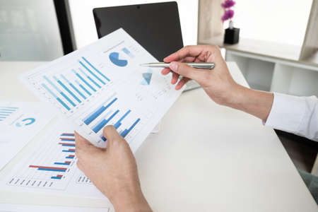 Businessman is analyzing marketing strategy from the selling performance graph in the office room, Finance and accounting concept.の写真素材