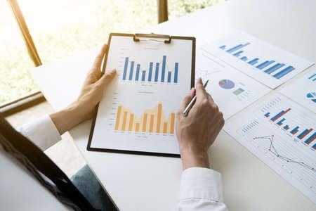 Businessman is analyzing marketing strategy from the selling performance graph in the office room, Finance and accounting concept.の写真素材