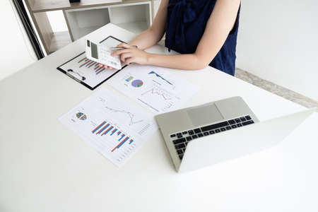 Business women is calculating revenue from graph in the room and work from home, Finance and accounting concept.の写真素材