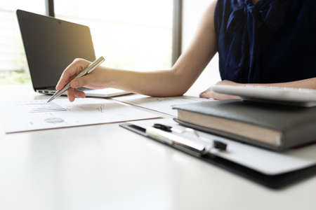 Business women is analyzing marketing strategy from the selling performance graph in the room and work from home, Finance and accounting concept.の写真素材