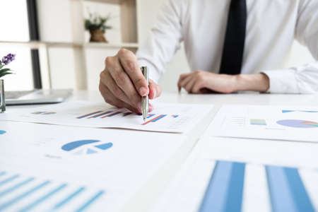 Businessman is analyzing marketing strategy from the selling performance graph in the office room, Finance and accounting concept.の写真素材