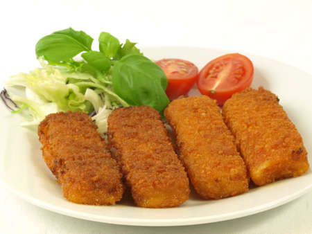 Four fish fingers for dinner with tomato and saladの写真素材