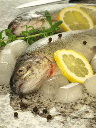Two trouts with lemon, pepper and rosemare, closeup