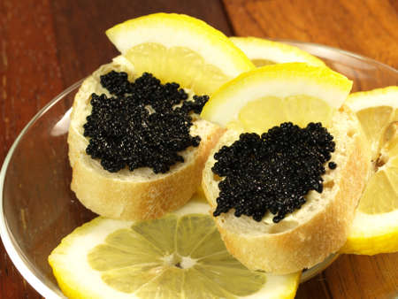 Sandwiches with black caviar and lemon slicesの写真素材