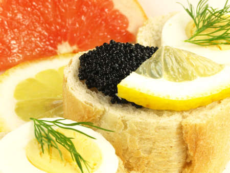Bread, caviar, egg, and slices of citrusの写真素材