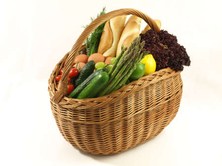 Basket full of vegetables and bread, studio isolatedの写真素材