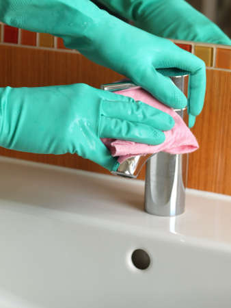 Closeup of cleaning a faucet in bath
