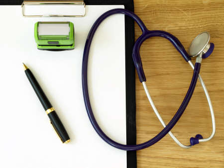 Doctor's equipment: stethoscope, stamp, notebook and pen