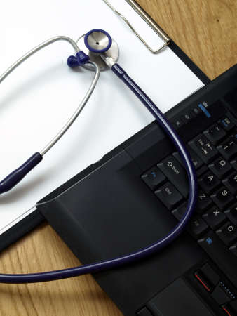 Medical notes and laptop on a doctor's desk. 