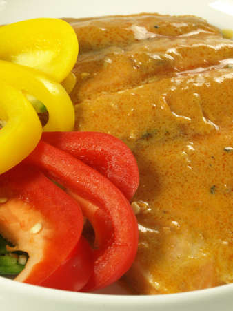 Closeup of salmon in curry sauce and paprikaの写真素材