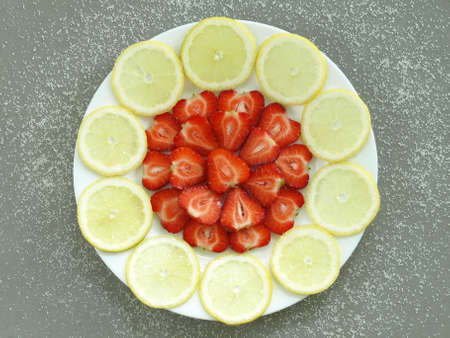 Plate of strawberries and lemon pieces, bird eye viewの写真素材