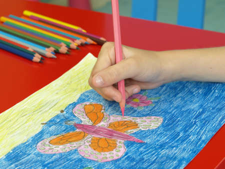 Child hand painting a colorful drawing, close upの写真素材