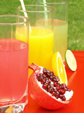 Closeup of three juices: pomegranate, orange, limeの写真素材