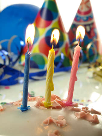 Third birthday cake with lighted three candles in close upの写真素材