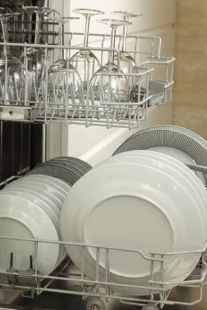 Open dishwasher full of plates, close up
