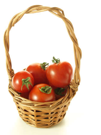 Cherry tomatoes in the wicker on white backgroundの写真素材