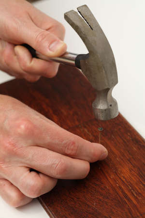 Closeup of nailing into a wooden board 