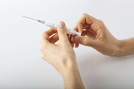 Womans hands preparing a syringe to injection