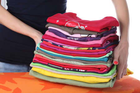 Woman raising up coloured pile of clothes