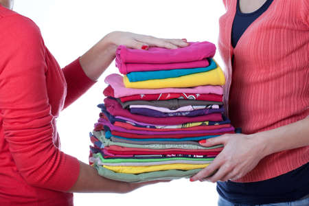 Two homemakers with heap of colorful ironed washind