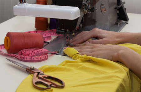 Dressmaker's hands making a dress, sewing machineの写真素材
