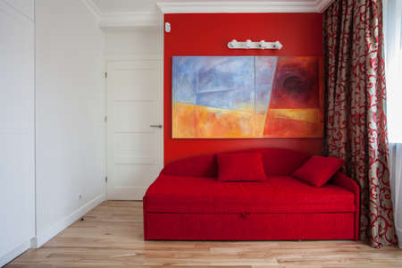 Teenager's room with a red wall and sofa