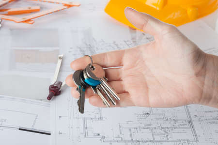 Architect's hand holding keys to a new houseの写真素材