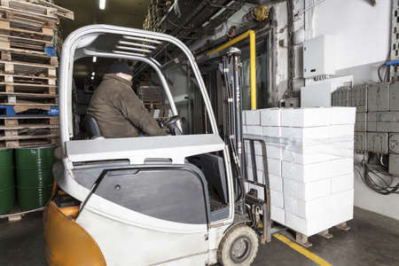 Logistics center and a working forklift, horizontalの写真素材