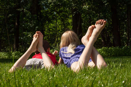 A boy and a girl lying and relaxing on the grass