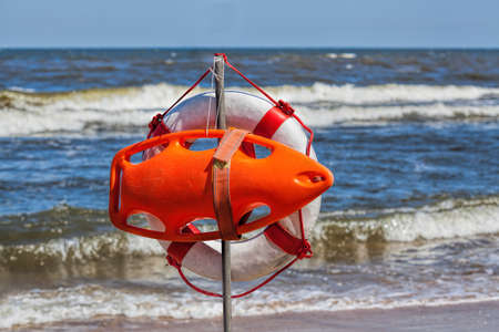 Lifebuoy hanging at sunny and windy seashore