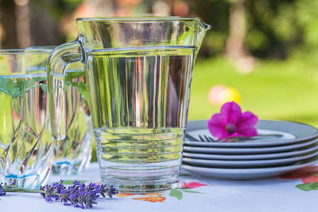 Table with cool drinks and plates for party