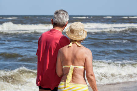 Curious seniors looking at blue beautiful seaの写真素材